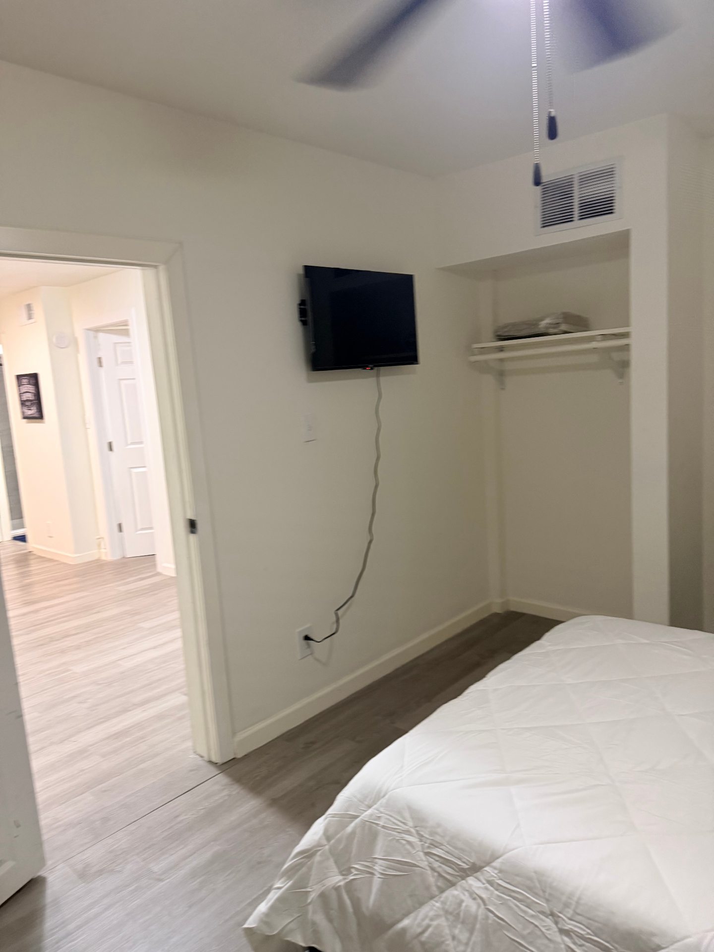 Cosby House — bedroom view toward hallway with mounted TV and ceiling fan