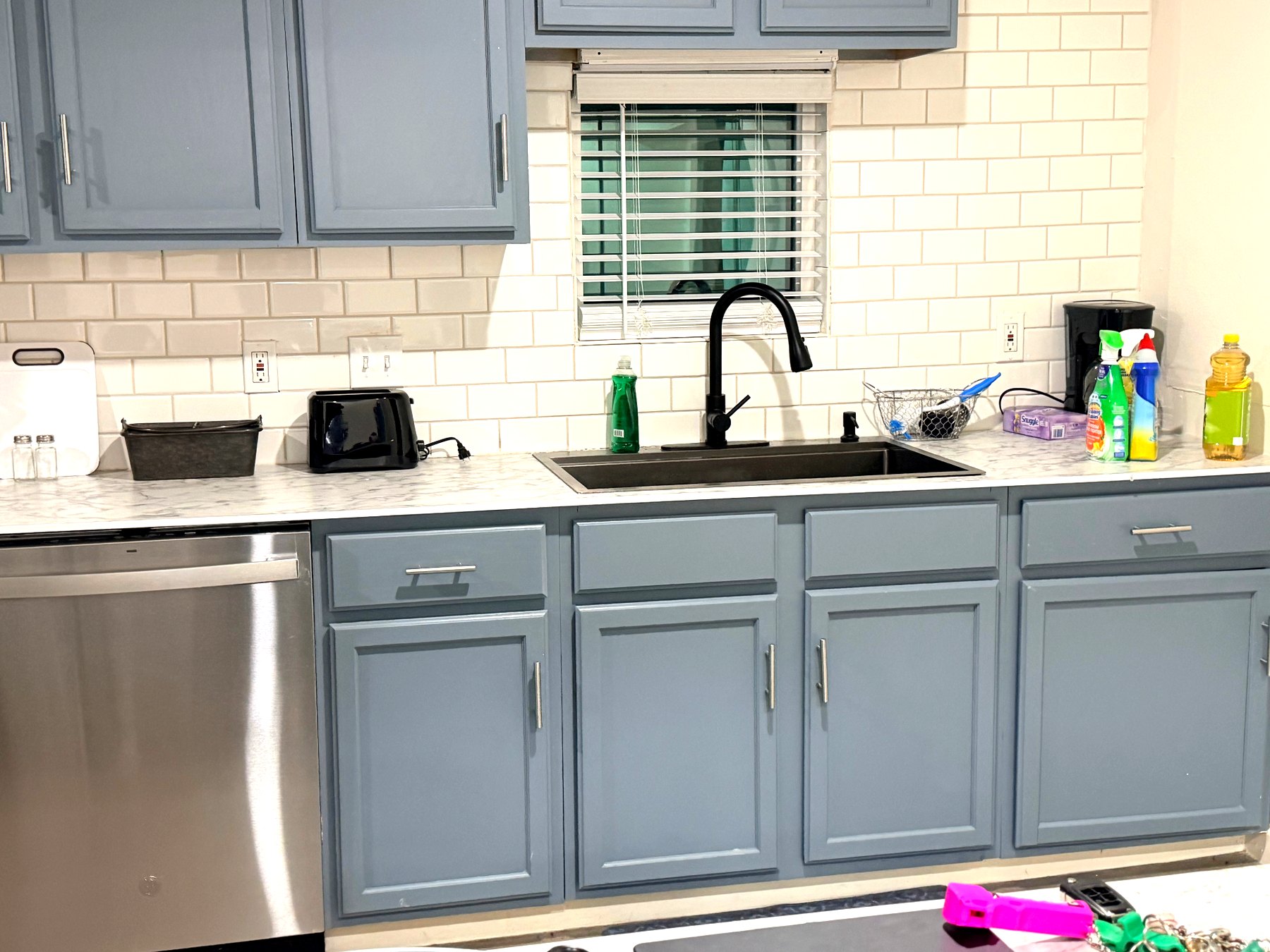 Cosby House — kitchen with blue cabinets, subway tile backsplash and stainless dishwasher