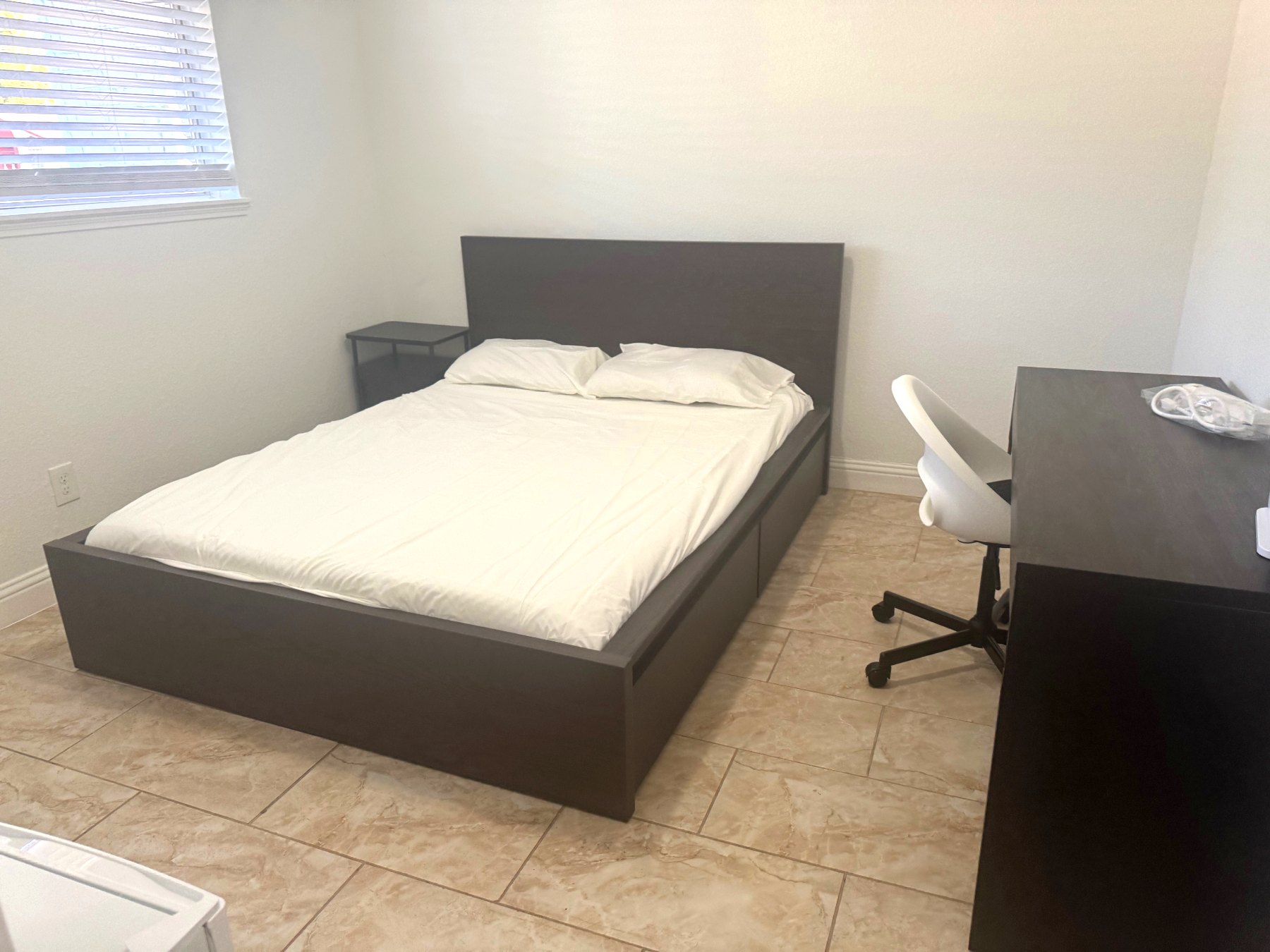 Rinn House — spacious private bedroom with tile floor, desk and nightstand