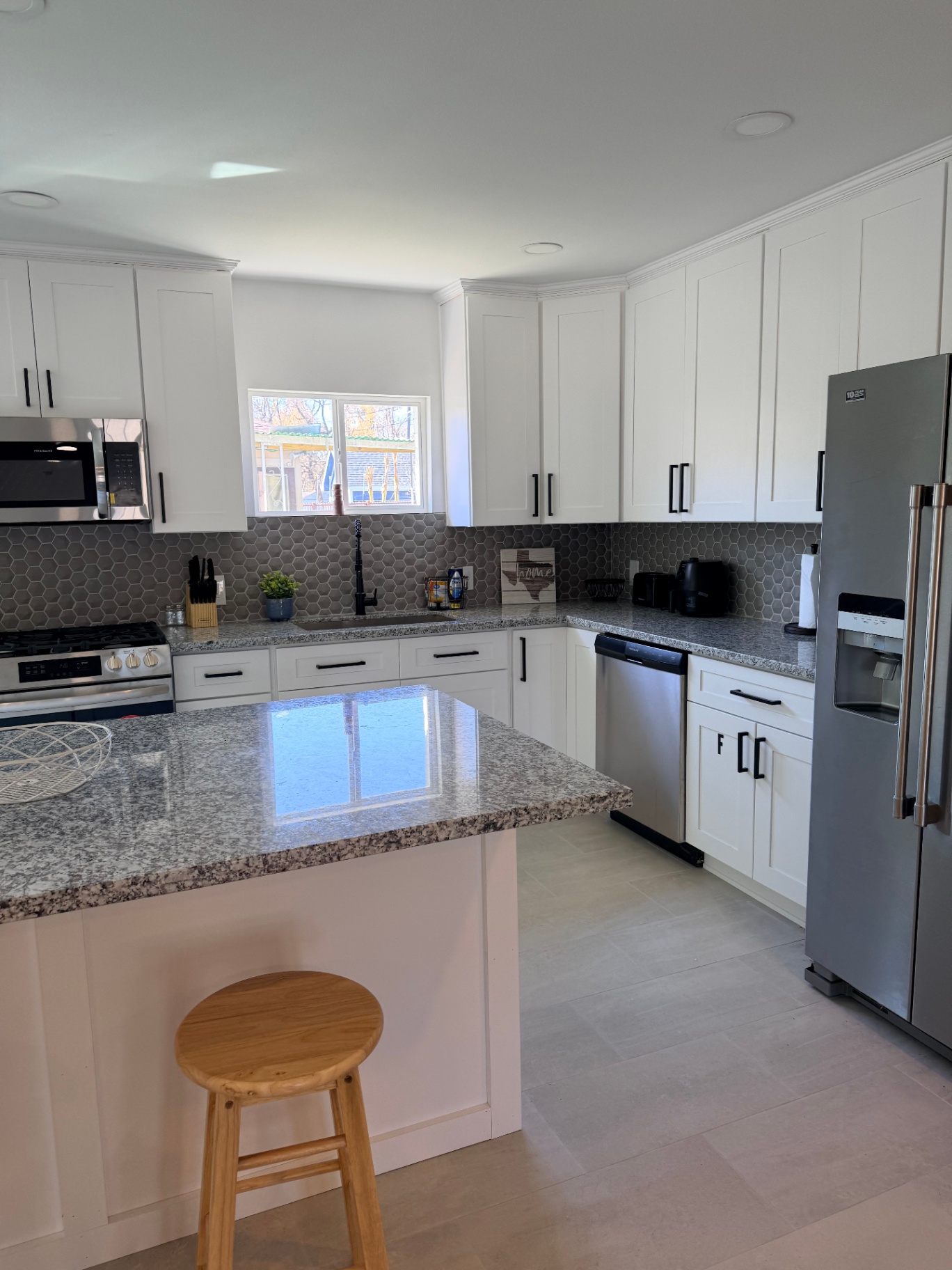 Tilgham House — bright kitchen with white cabinets and granite island