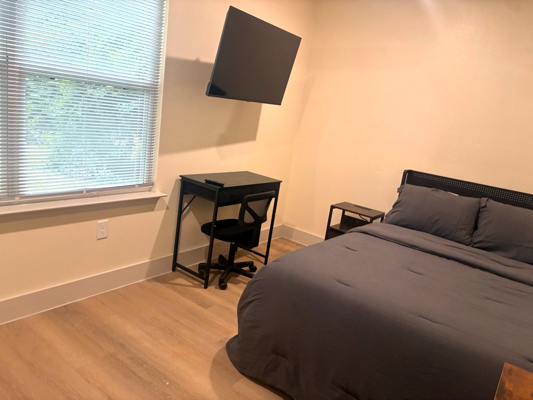 Furnished bedroom with desk workspace and large window
