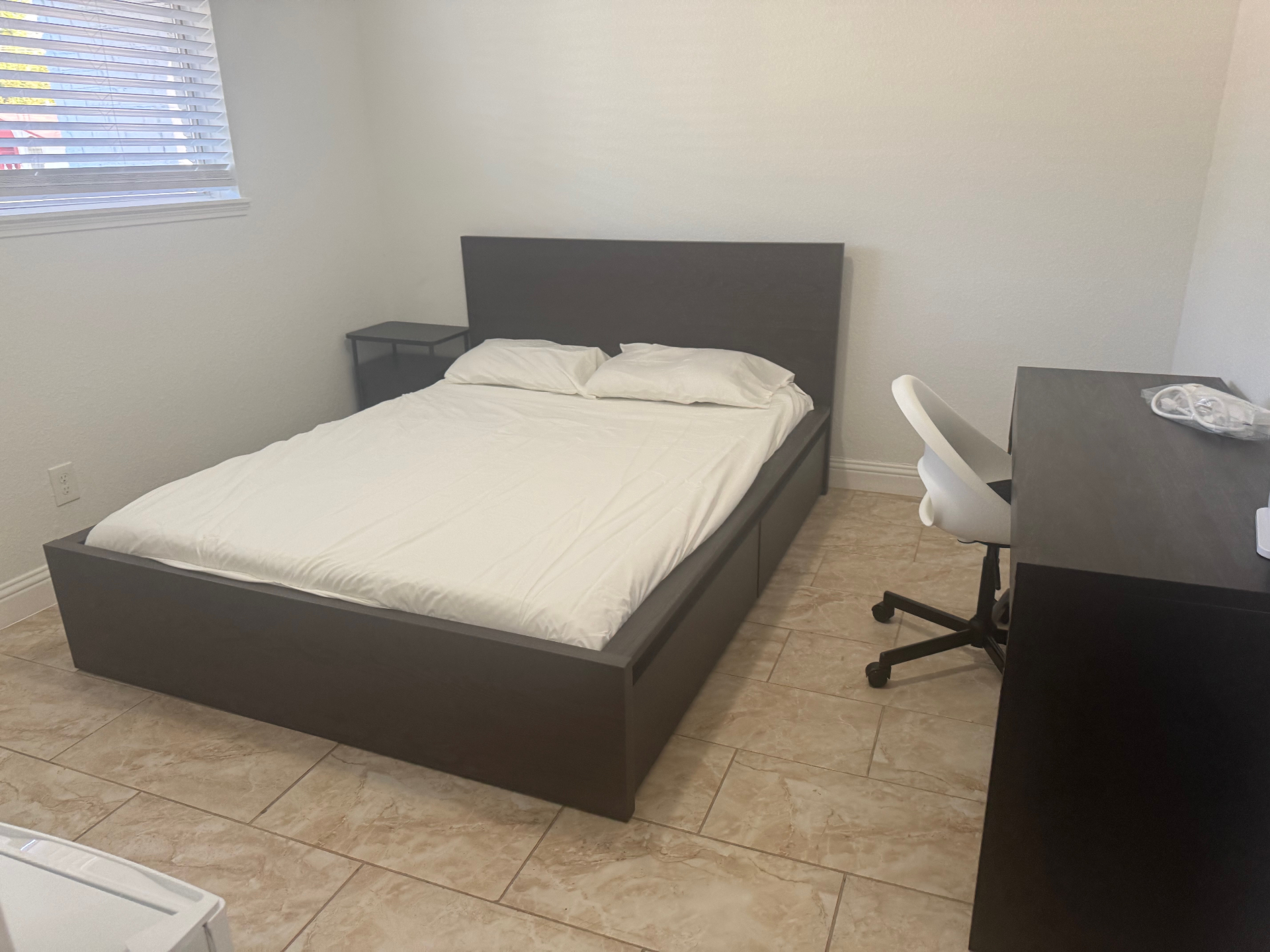 Rinn House — spacious private bedroom with tile floor, desk and nightstand
