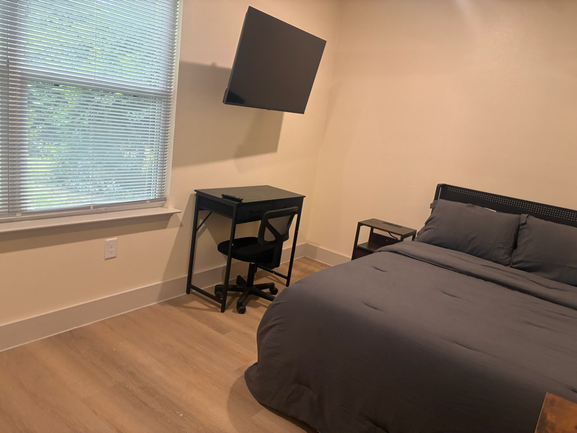 Furnished bedroom with desk workspace and large window