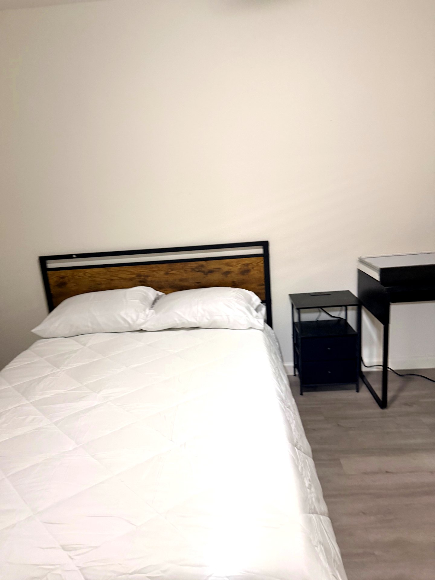 Cosby House — private bedroom with wood-accent headboard and workspace