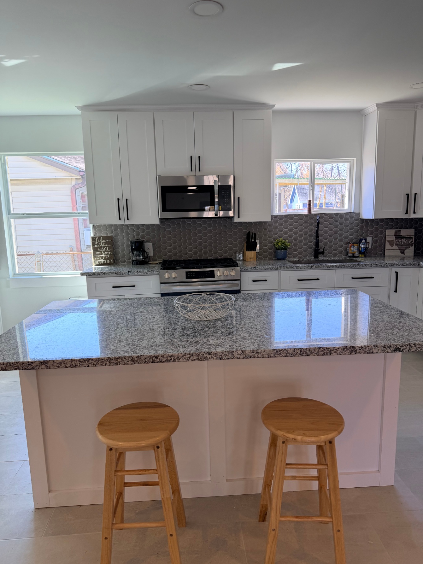 Tilgham House — kitchen island with bar stools and hex tile backsplash