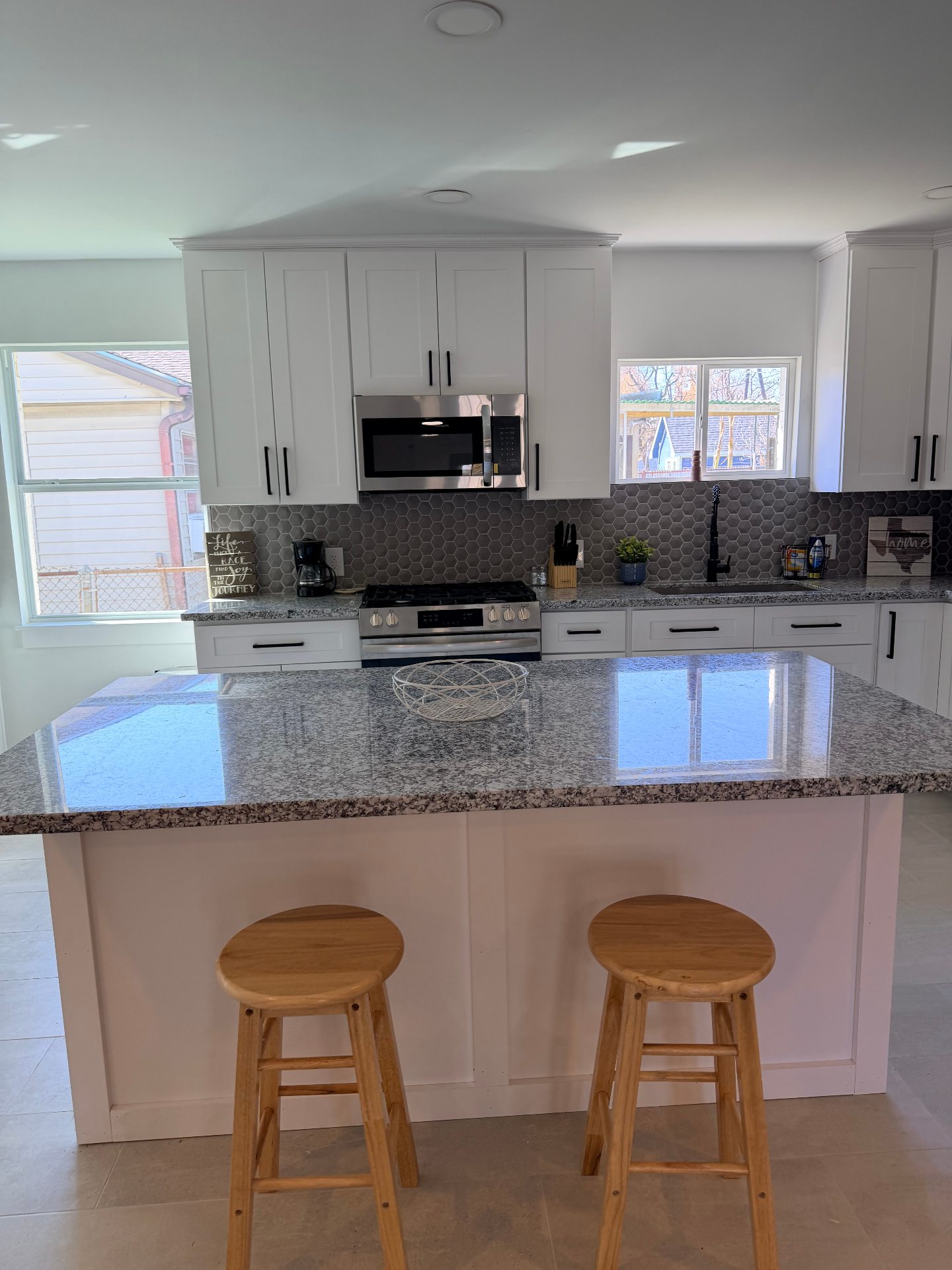 Tilgham House — kitchen island with wooden bar stools and open layout