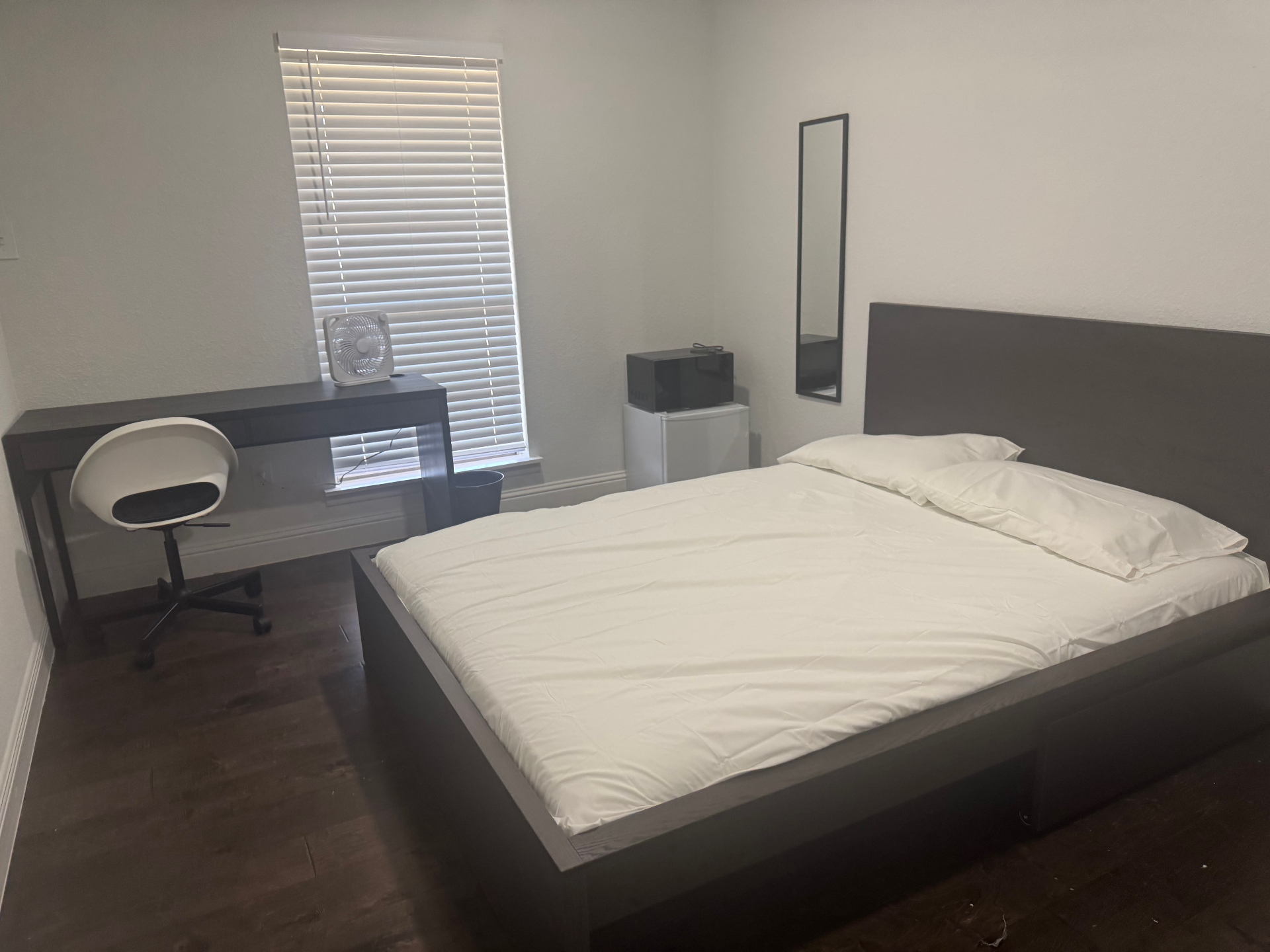 Rinn House — furnished private bedroom with queen bed, desk and mini fridge