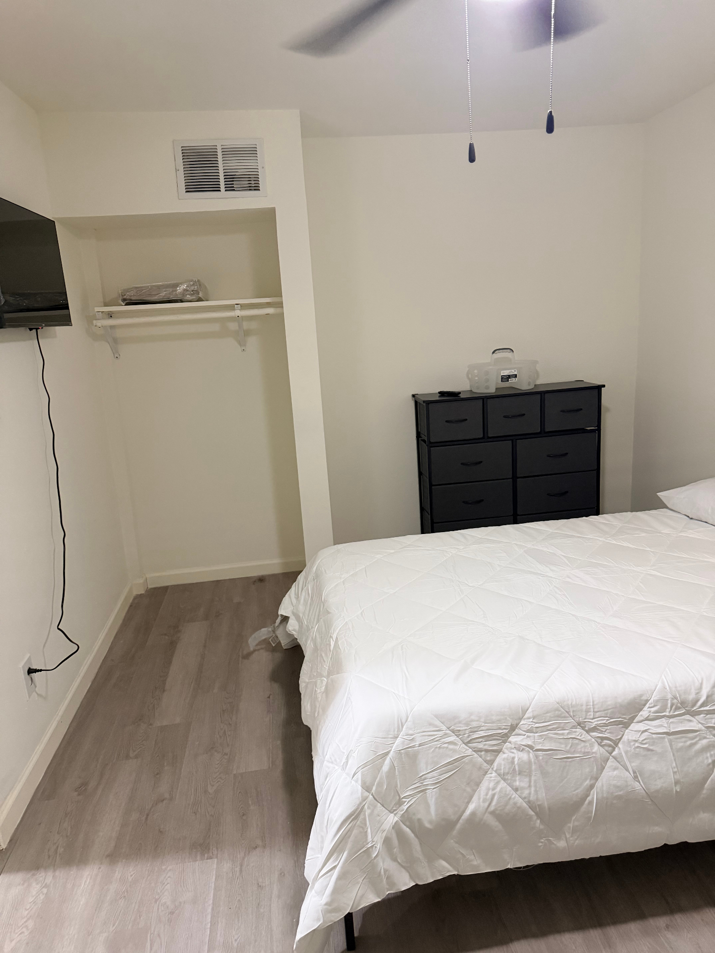 Cosby House — private bedroom with queen bed, dresser, wall-mounted TV and closet