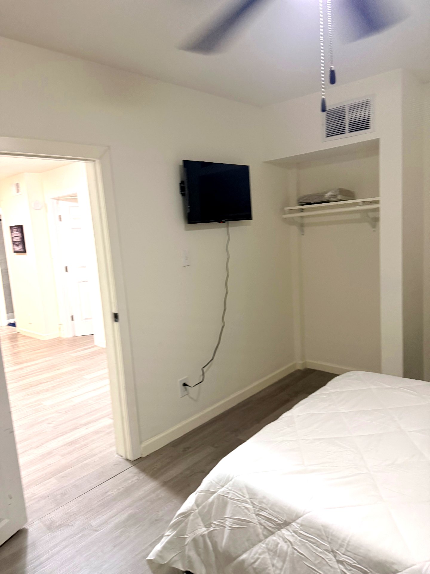 Cosby House — bedroom view toward hallway with mounted TV and ceiling fan