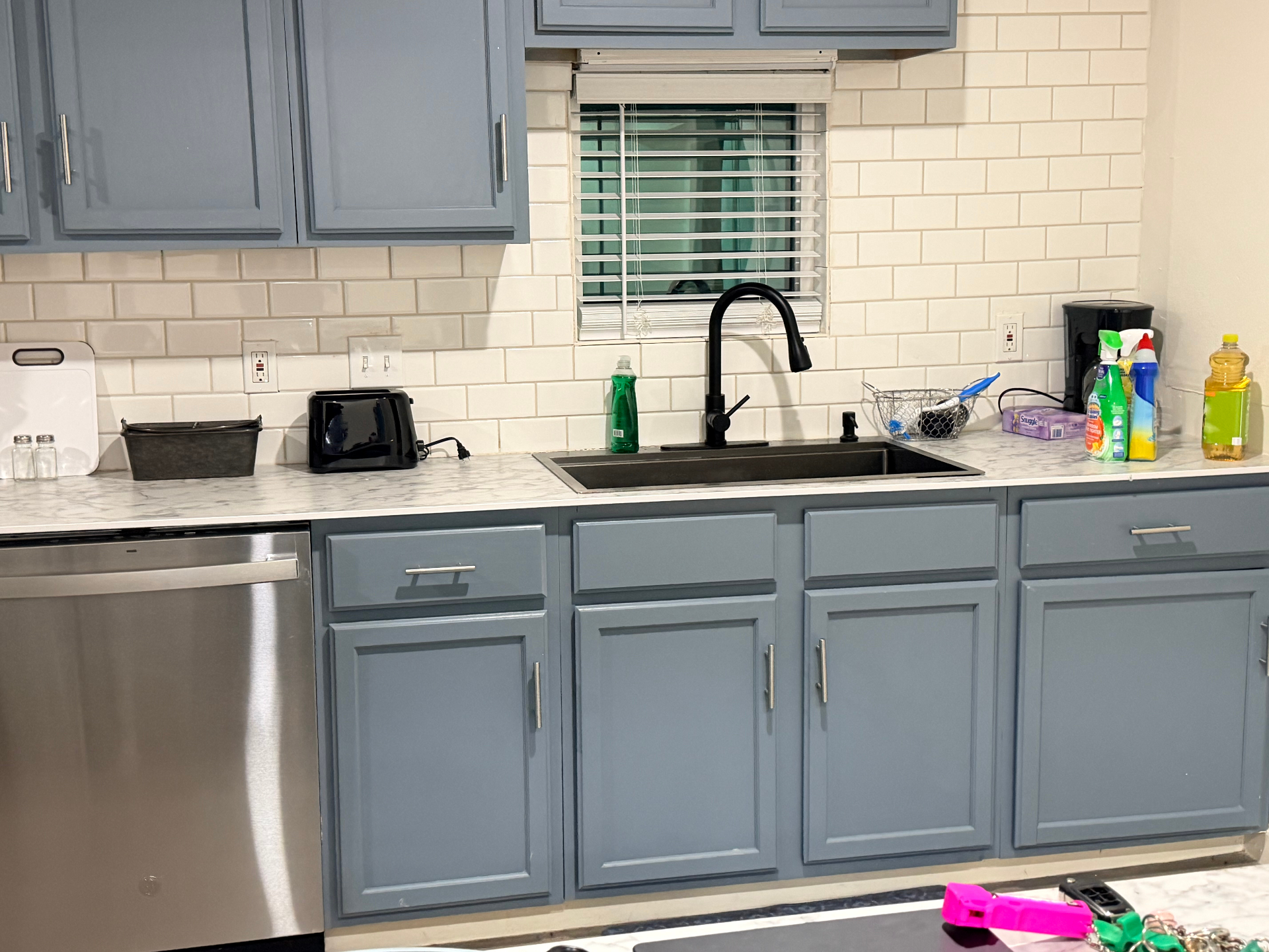 Cosby House — kitchen with blue cabinets, subway tile backsplash and stainless dishwasher