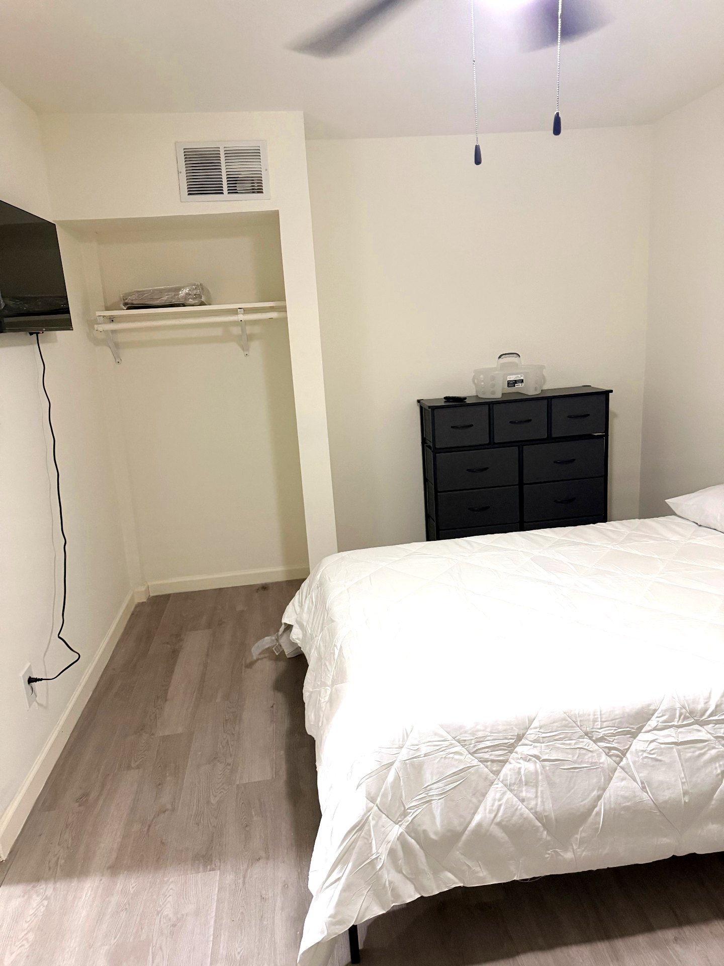 Cosby House — private bedroom with queen bed, dresser, wall-mounted TV and closet